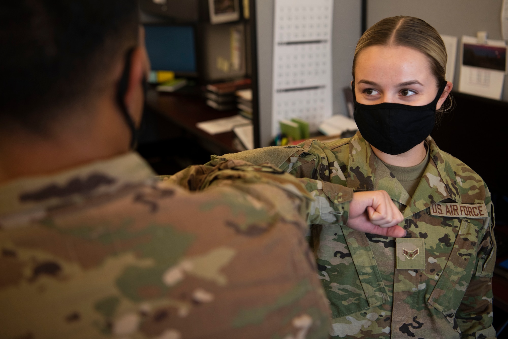 Airman 1st Class Vladyslava Iakovenko, 21st Comptroller Squadron financial operations technician, elbow bumps a fellow Airman Sept. 30, 2020, at Schriever Air Force Base, Colorado. Practicing proper respect and office etiquette is integral in maintaining the military, comrade and credibility. (U.S. Space Force photo by Airman 1st Class Jonathan Whitely)