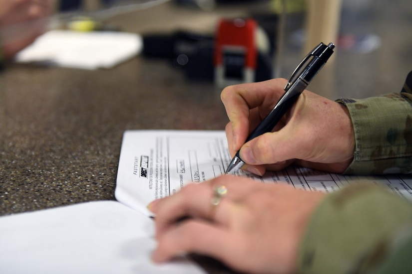Person writes on paper with a pen.