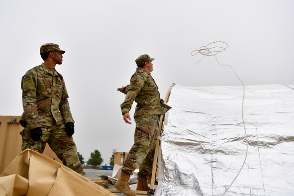 Master Sgt Dusting Fullerton, 434th Civil Engineer Squadron heavy repair superintendent throws a rope over a tent to pull the cover over on Grissom Air Reserve Base, September 10, 2020. Airmen from the 434th Civil Engineer Squadron recently put their training to the test, setting up a bare base with 24 tents, in roughly 10 hours.