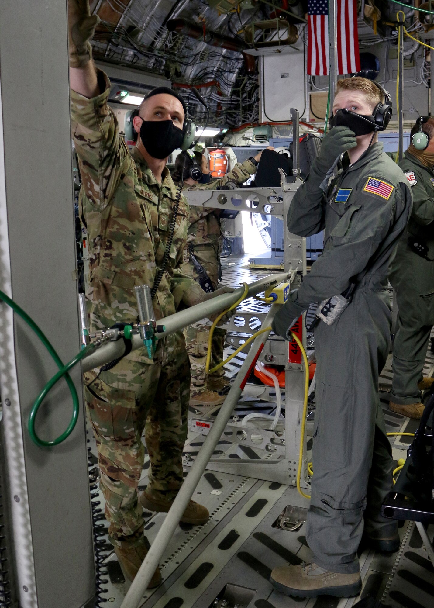 Tech. Sgt. Nickolaus Burns (left), 445th Aeromedical Evacuation Squadron flight instructor, shows a U.S. Air Force School of Aerospace Medicine student how to properly configure the medical equipment on a 445th Airlift Wing C-17 Globemaster III in preparation for an aeromedical evacuation training flight Sept. 14, 2020. Burns was one of four Reserve Citizen Airmen who augmented active duty cadre at the schoolhouse in September.