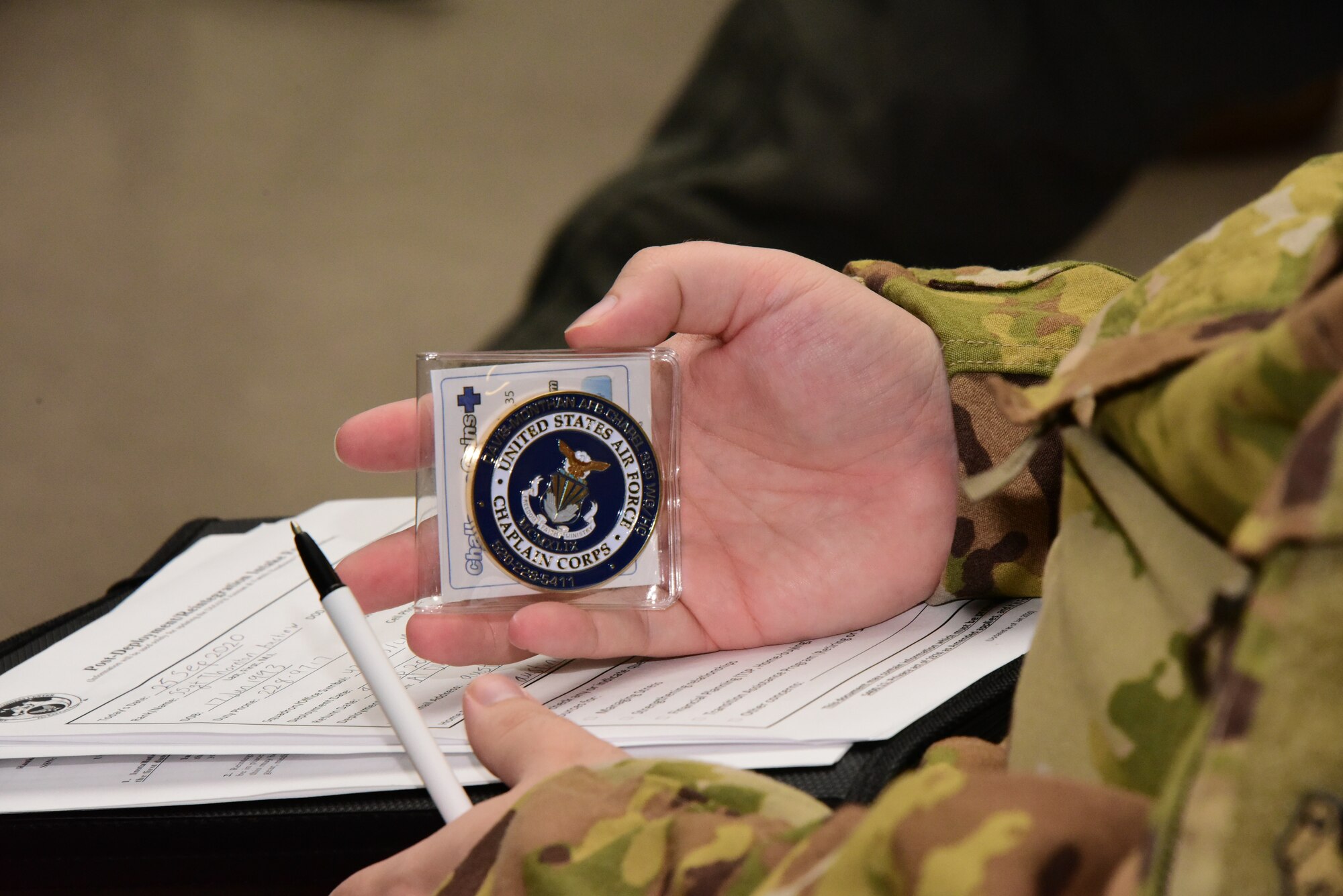 A photo of an Airman holding a coin
