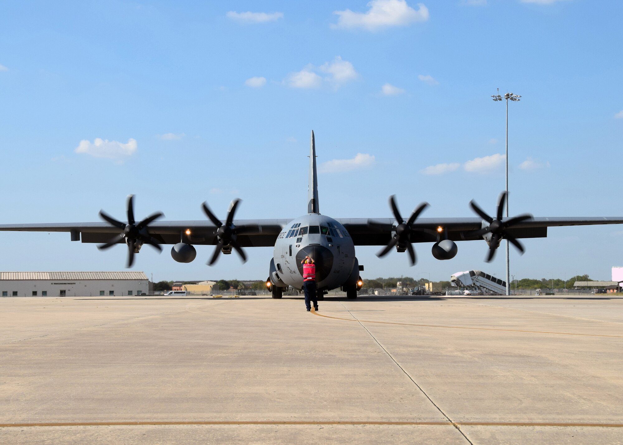 Robert Huth, Joint Base San Antonio transient alert marshaller, directs a WC-130J Hercules “Hurricane Hunter” weather reconnaissance aircraft from the 403rd Wing at Keesler Air Force Base, Mississippi, into a parking spot on the 433rd Airlift Wing ramp at Joint Base San Antonio-Lackland, Texas Oct. 6, 2020.