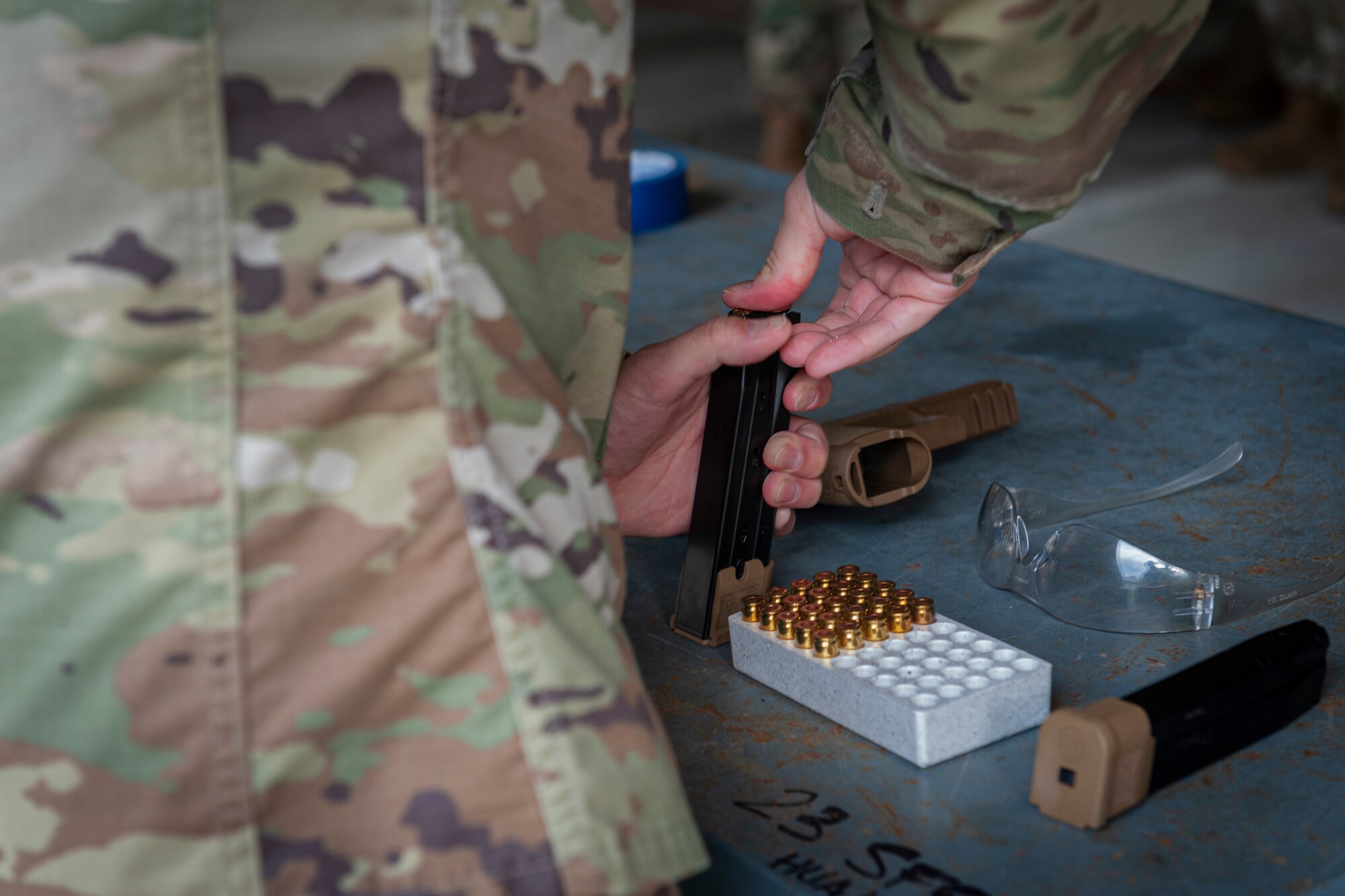 Photo of an Airman loading ammo into a magazine