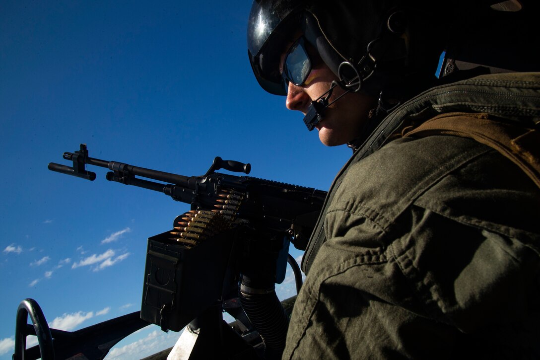 A U.S. Marine with Marine Light Attack Helicopter Squadron 367 looks out at the ocean during an aerial exercise, Marine Corps Base Hawaii, Sept. 17, 2020. The operation was conducted in order to produce readiness and strengthen cohesion within the unit. (U.S. Marine Corps photo by Lance Cpl. Shane Linder)