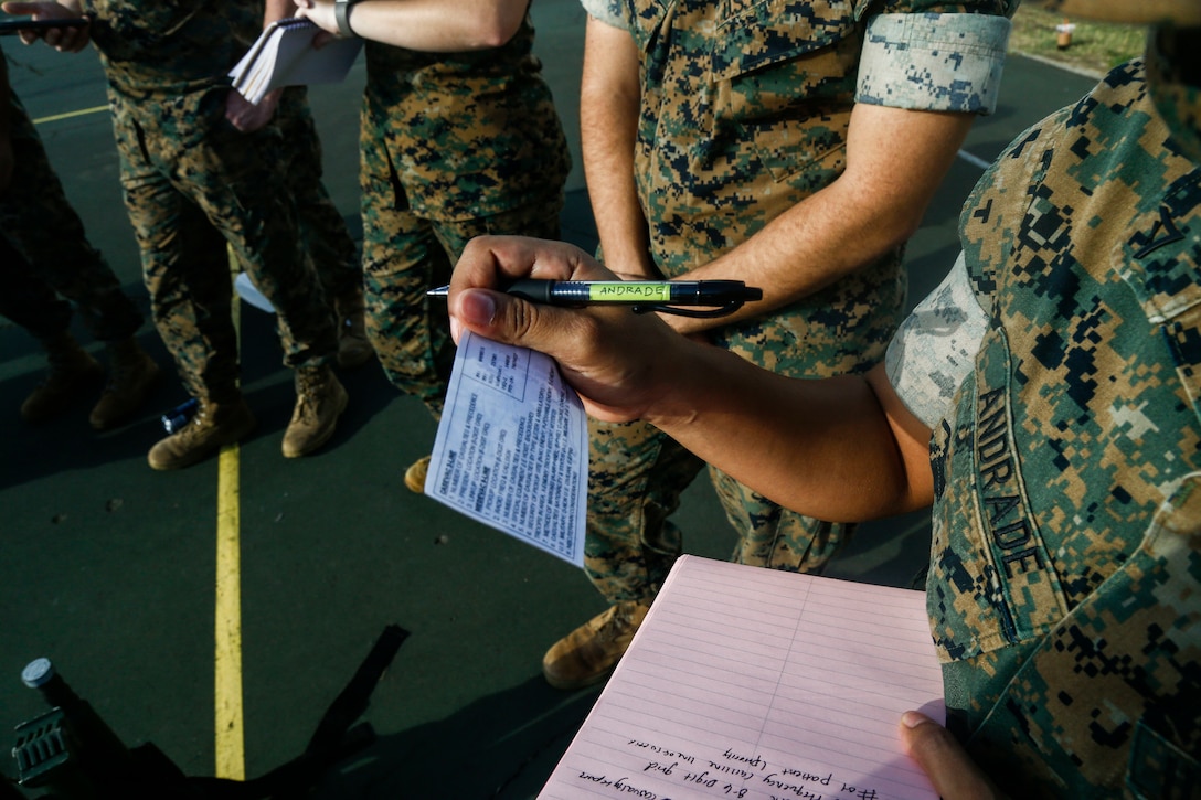 U.S. Marine Corps Lance Cpl. Itzel Andrade, an administration specialist with Headquarters Company, Headquarters Battalion, Marine Corps Base Hawaii reviews the nine line order of communication while taking notes, MCBH, Oct. 6, 2020. This training was conducted in order to familiarize HQBN Marines with the process of a casualty evacuation, increasing their expeditionary readiness. (U.S. Marine Corps photo by Lance Cpl. Shane Linder)