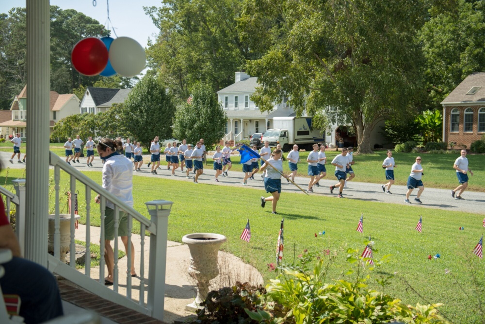 Airmen run past neighborhood homes in formation