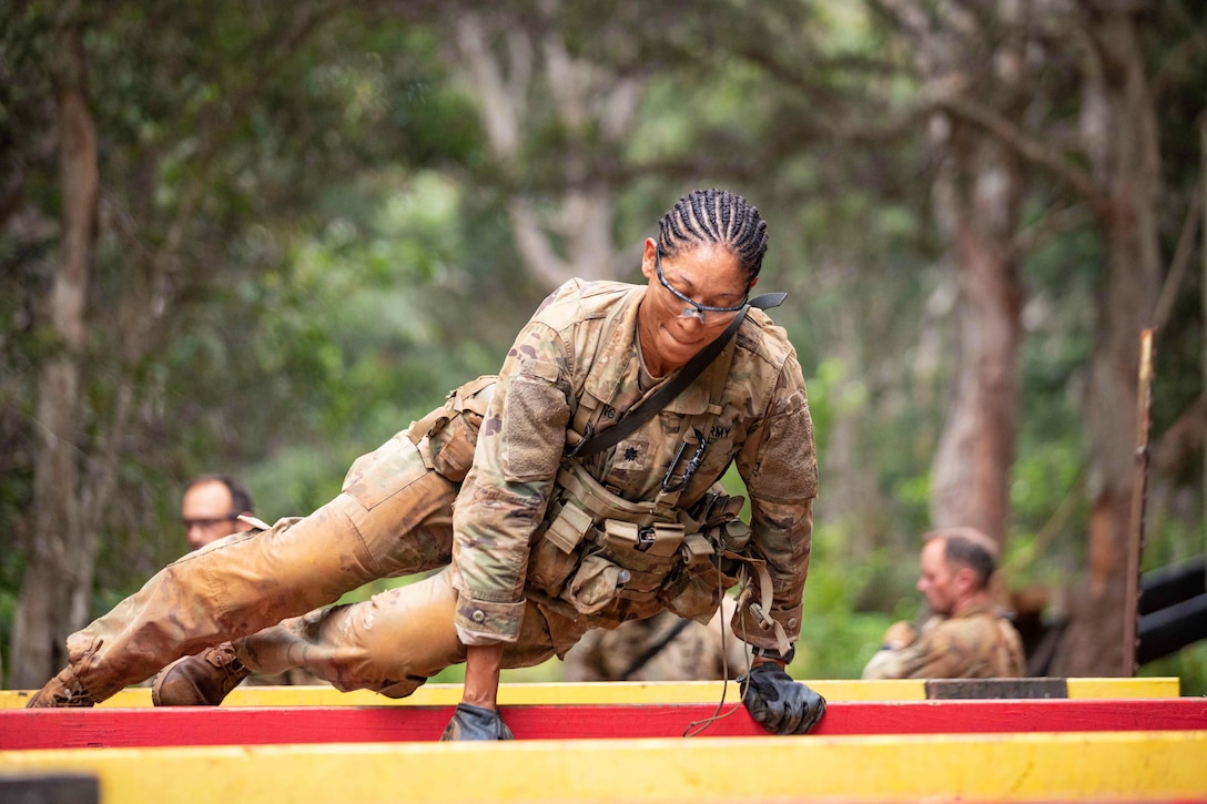 A soldier jumps over hurdles.