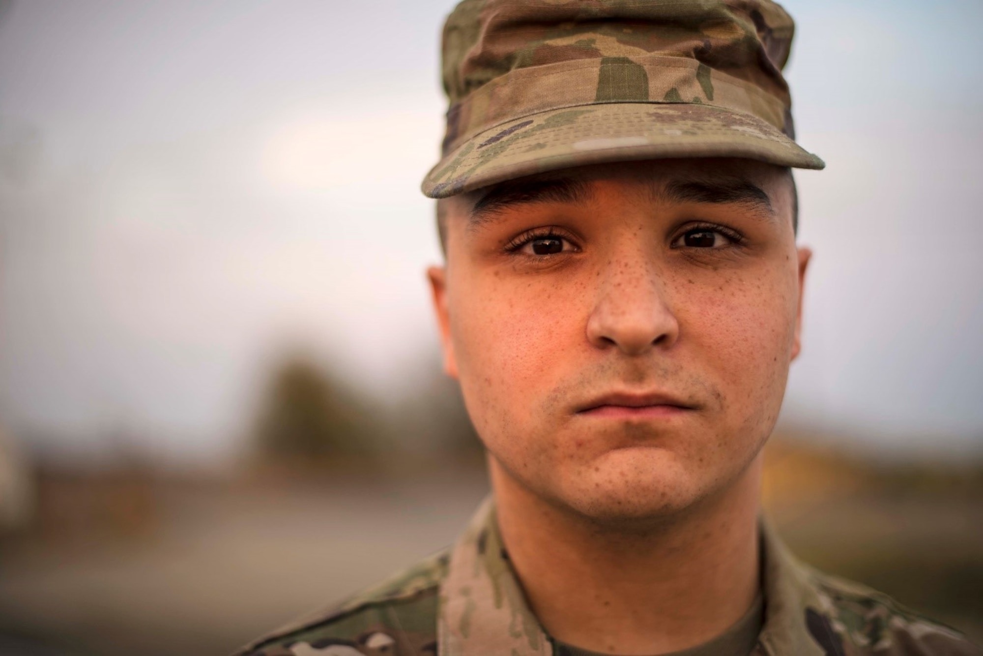 A man in a military uniform stares at the camera.