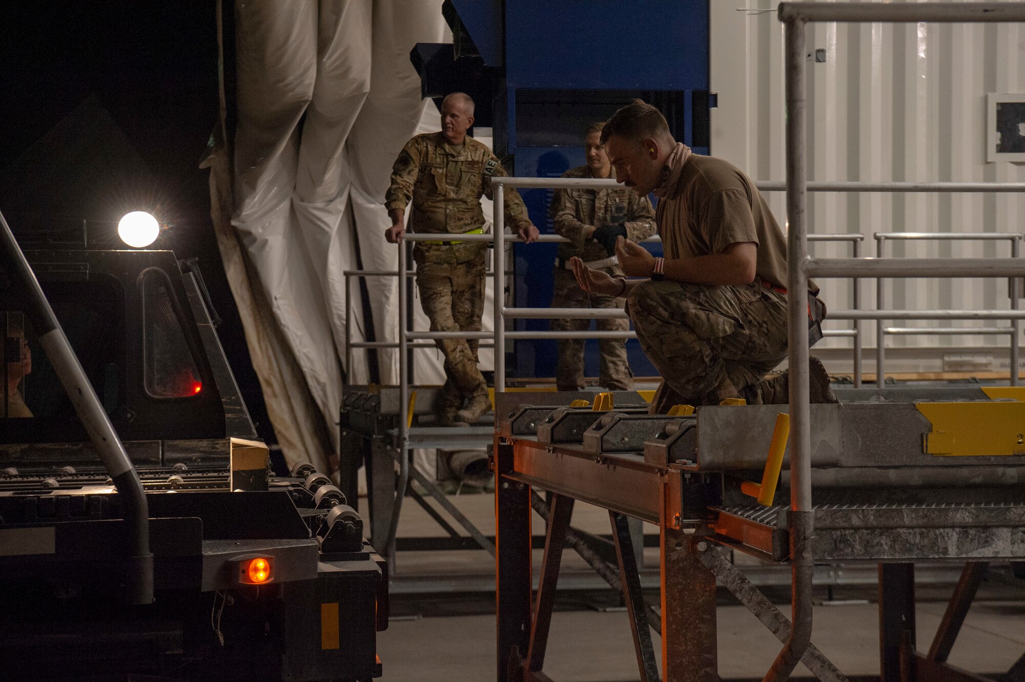 Airmen load a specialized medical container designed to transport individuals with infectious diseases into a clamshell hangar on the flight line of Al Udeid Air Base, Qatar, Sept. 25, 2020. The 379th Expeditionary Aeromedical Evacuation Squadron received the Negatively Pressurized Conex-Lite, or NPC-L, shortly after the Negatively Pressurized Conex. Both medical containers will enable the 379th EAES to safely and expeditiously transport personnel with COVID-19, or other infectious diseases, to higher echelons of care from military installations where isolation or treatment may not be available.