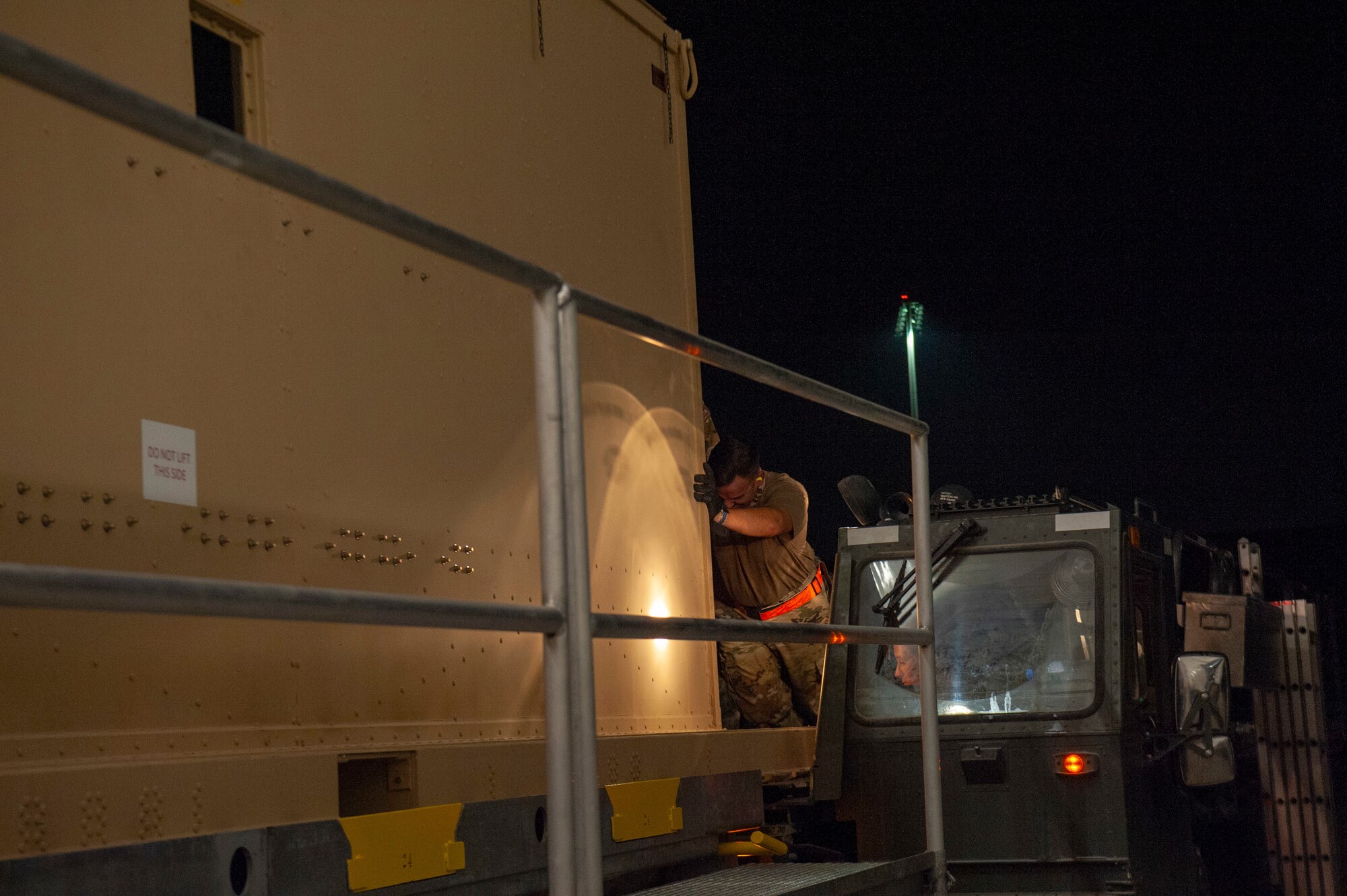 Airmen load a specialized medical container designed to transport individuals with infectious diseases into a clamshell hangar on the flight line of Al Udeid Air Base, Qatar, Sept. 25, 2020. The Negatively Pressurized Conex-Lite, or NPC-L, was received by 379th Expeditionary Aeromedical Evacuation Squadron shortly after the Negatively Pressurized Conex. Both medical containers will enable the 379th EAES to safely and expeditiously transport personnel with COVID-19, or other infectious diseases, to higher echelons of care from military installations where isolation or treatment may not be available.