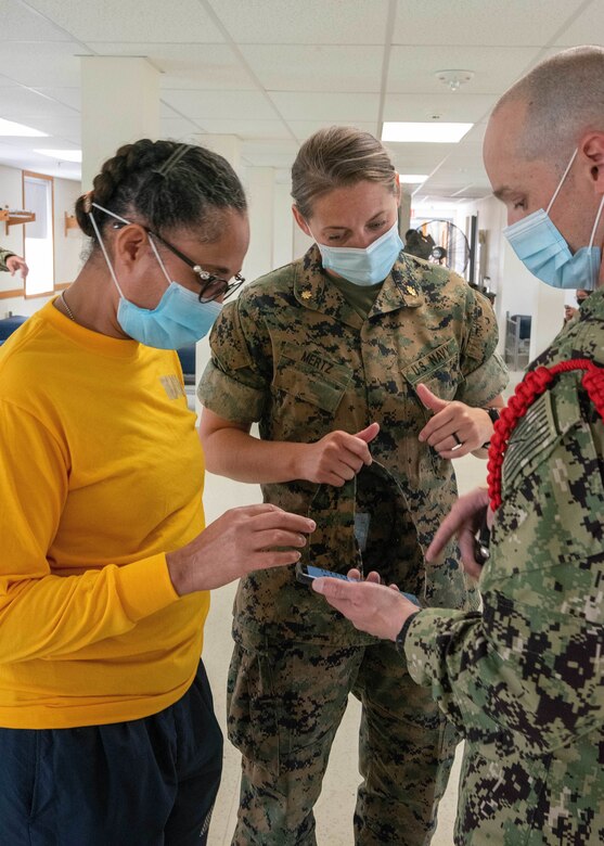 Sailors wearing face masks talking in a group.