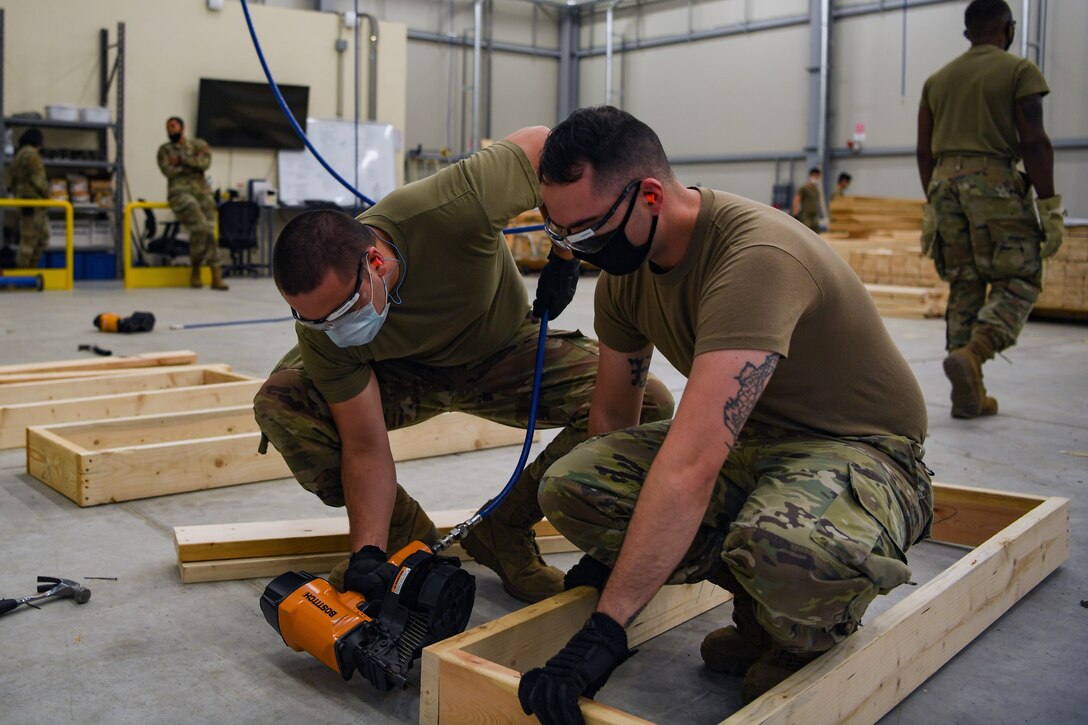 Airmen with the 731st Munitions Squadron build bracing for munitions during Waking Giant at Camp Darby, Italy, Oct. 7, 2020. The bracing was meant to keep munitions in place while being shipped inside an intermodal shipping container. (U.S. Air Force photo by Airman 1st Class Thomas S. Keisler IV)