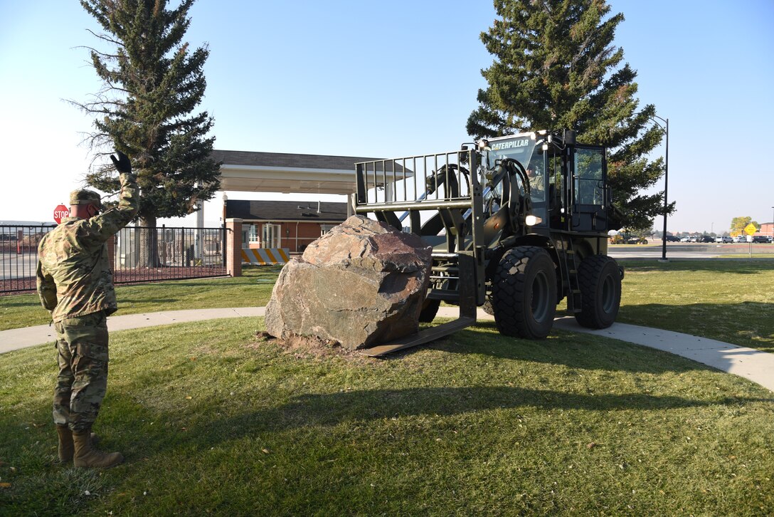 airmen loading memorial stone on forklift