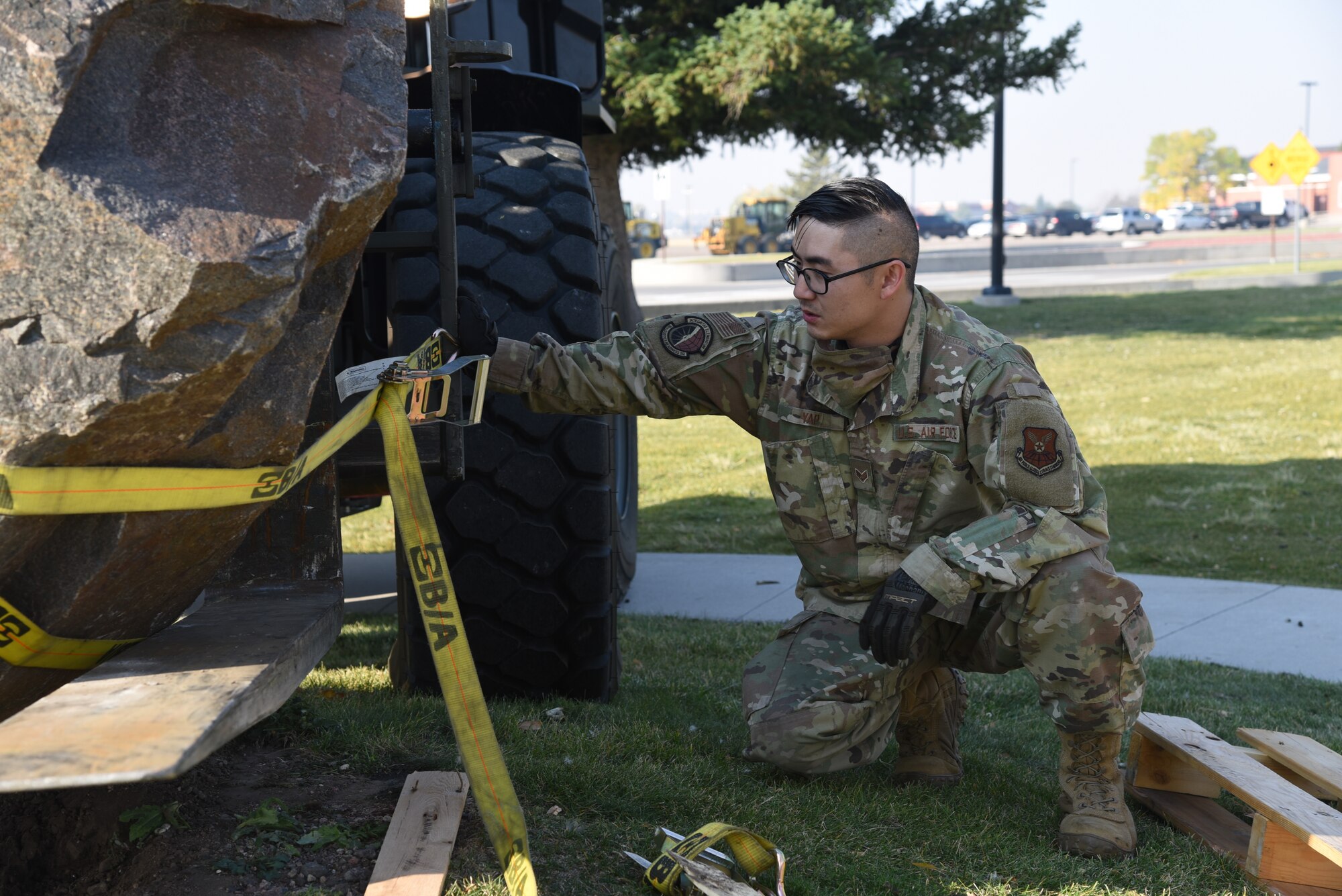 Airman placing straps on memorial stone