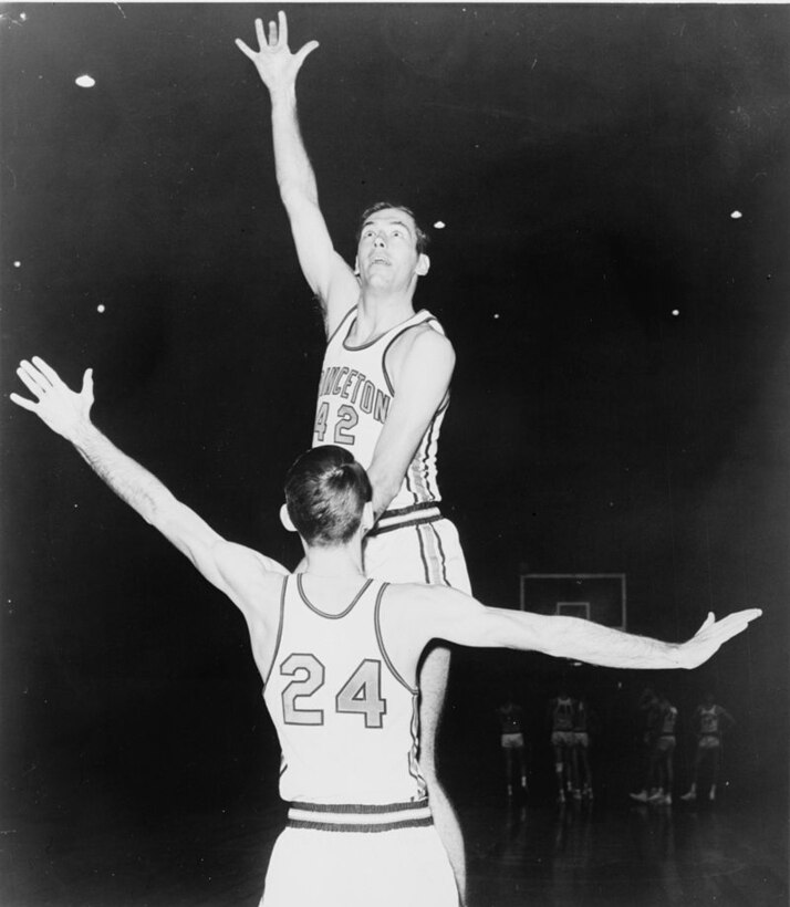 Men play basketball in a gymnasium.