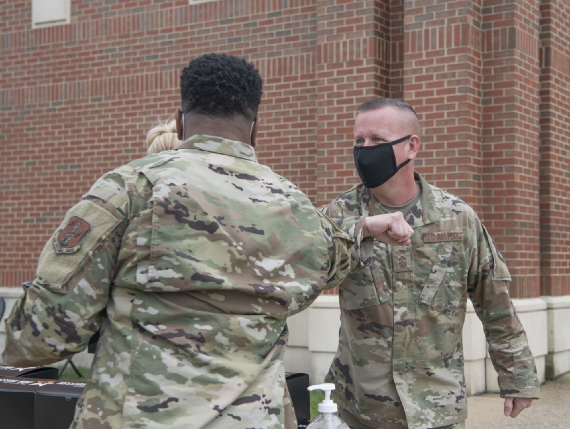 Two Airmen bump elbows