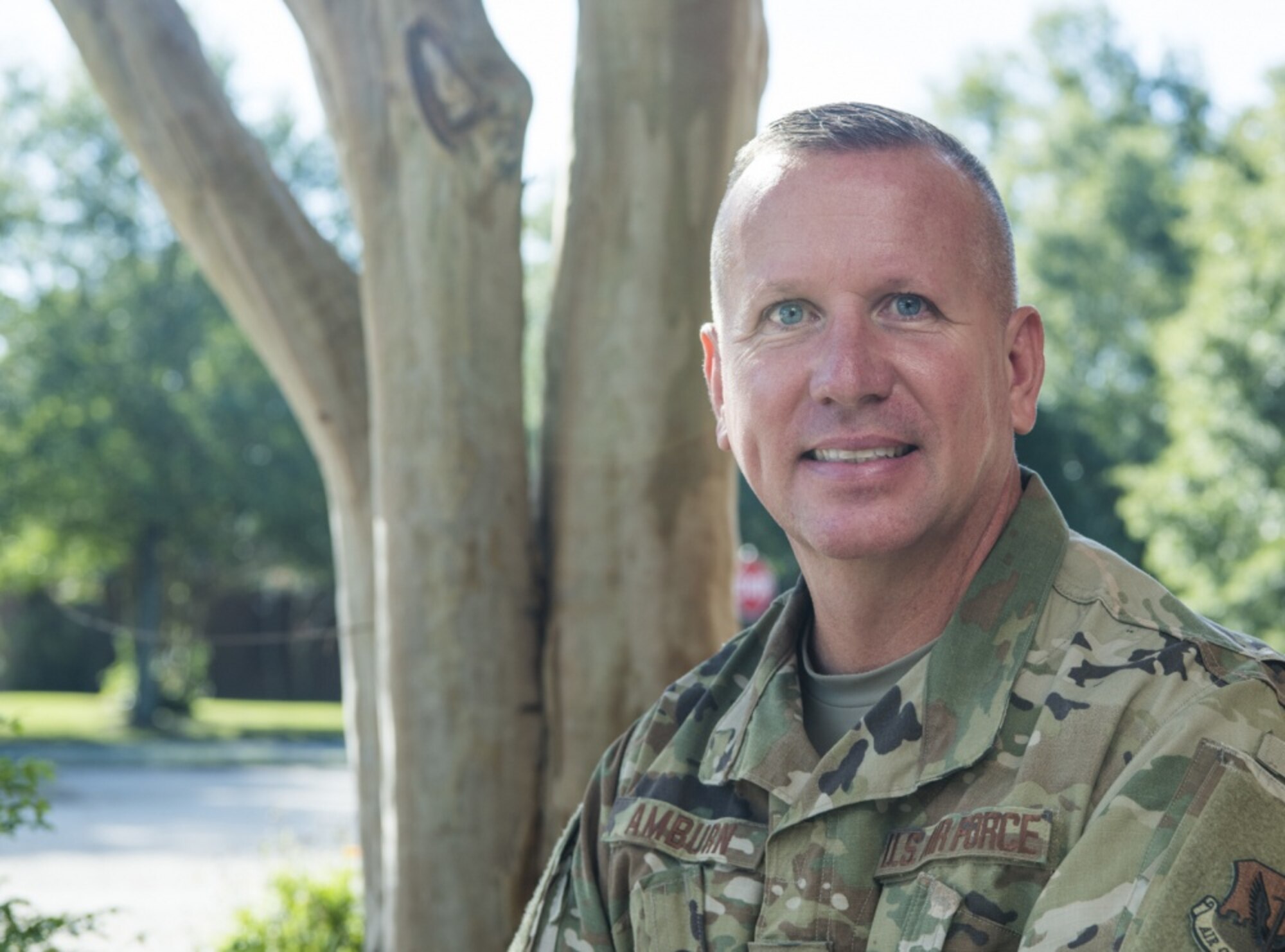 An Airman sitting by a tree