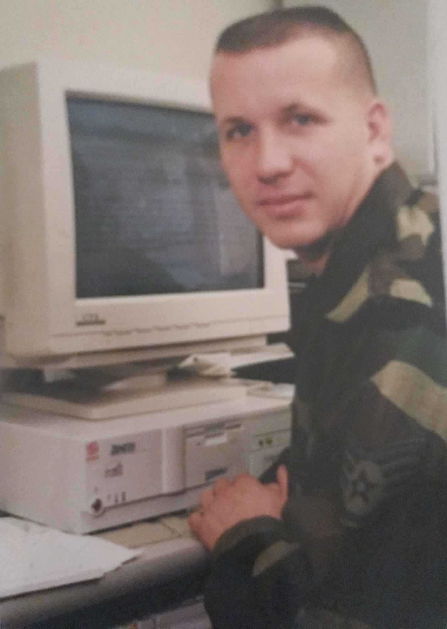 An old photo of an Airman at a computer