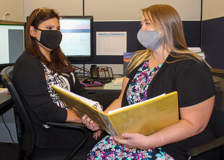 Jamina Caldera, 50th Force Support Squadron education services specialist and civilian training manager, left, and Lauren Clark, Force Development Flight education services specialist, review education documents Oct. 7, 2020, at Schriever Air Force Base, Colorado. The education center will help students apply for and find financial aid if they need to supplement the $750 lost from the tuition assistance program. (U.S. Space Force photo by Marcus Hill)