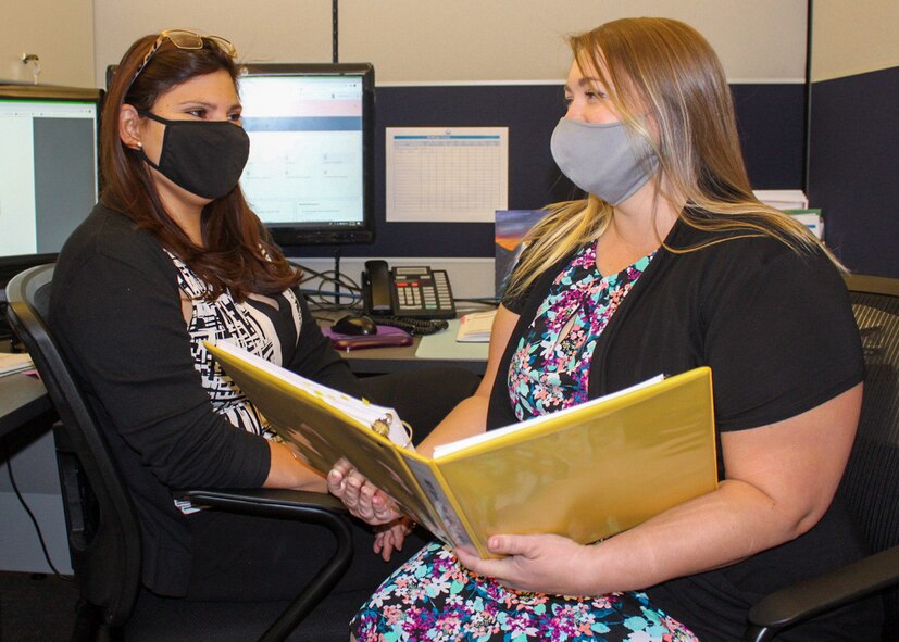 Jamina Caldera, 50th Force Support Squadron education services specialist and civilian training manager, left, and Lauren Clark, Force Development Flight education services specialist, review education documents Oct. 7, 2020, at Schriever Air Force Base, Colorado. The education center will help students apply for and find financial aid if they need to supplement the $750 lost from the tuition assistance program. (U.S. Space Force photo by Marcus Hill)
