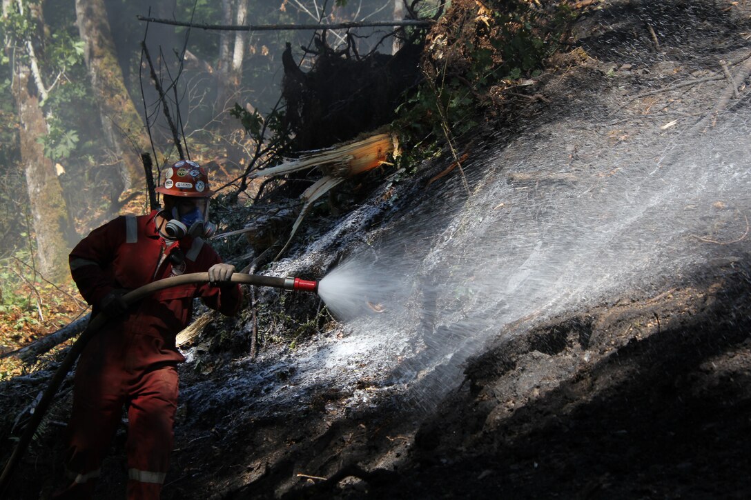 A contractor spays special foam on a coal fire at an abandoned Navy coal mine in Cumberland, Washington, August, 2020.
At the request of the Office of Surface Mining and Reclamation  the USACE Omaha District's rapid response team was asked to provide assistance. (Courtesy photo by Mr. Jeremy Ayala)