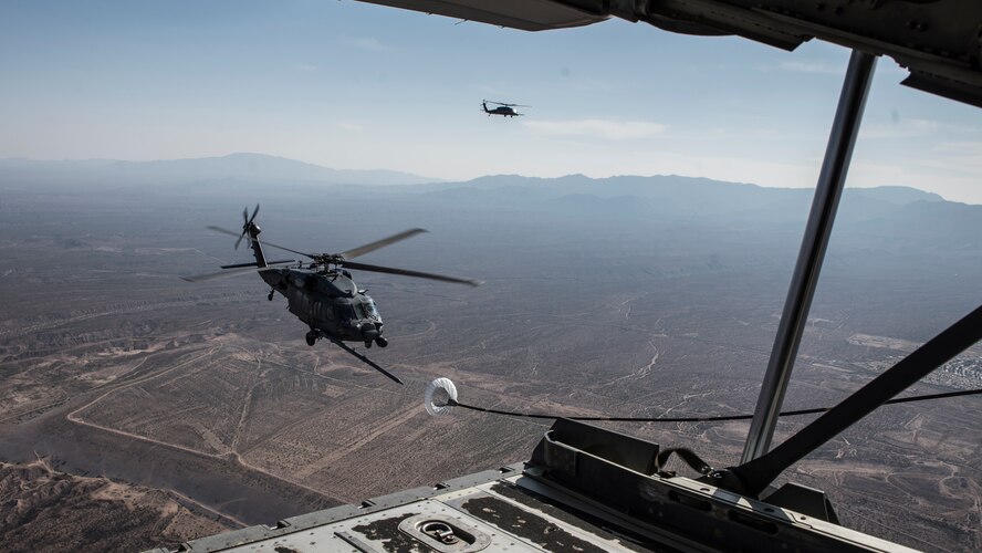 A photo of a helicopter performing air-to-air refueling