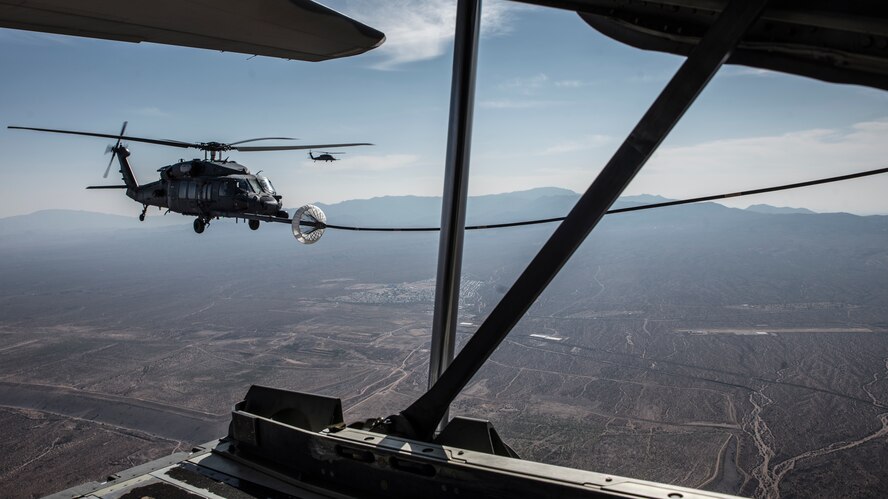 A photo of a helicopter performing air-to-air refueling