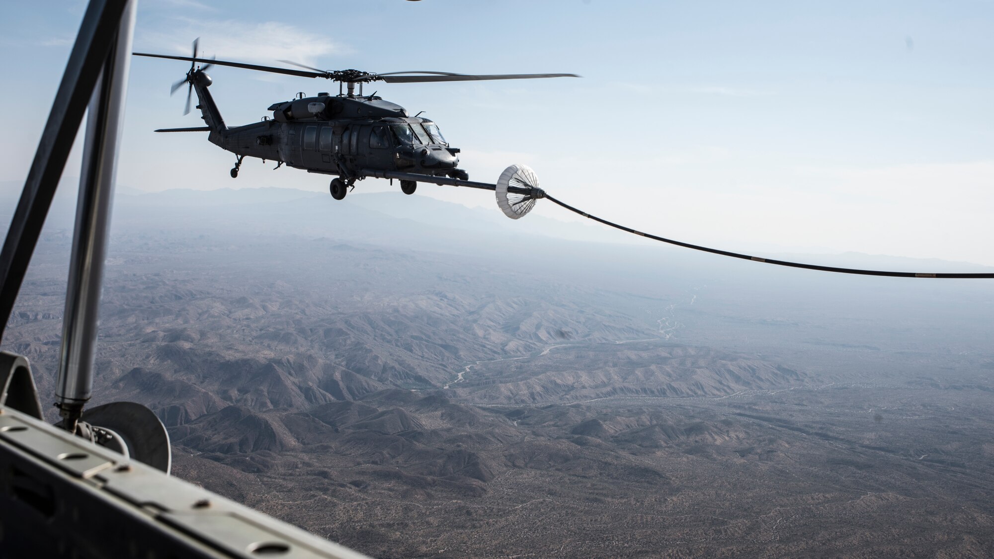 A photo of a helicopter performing air-to-air refueling