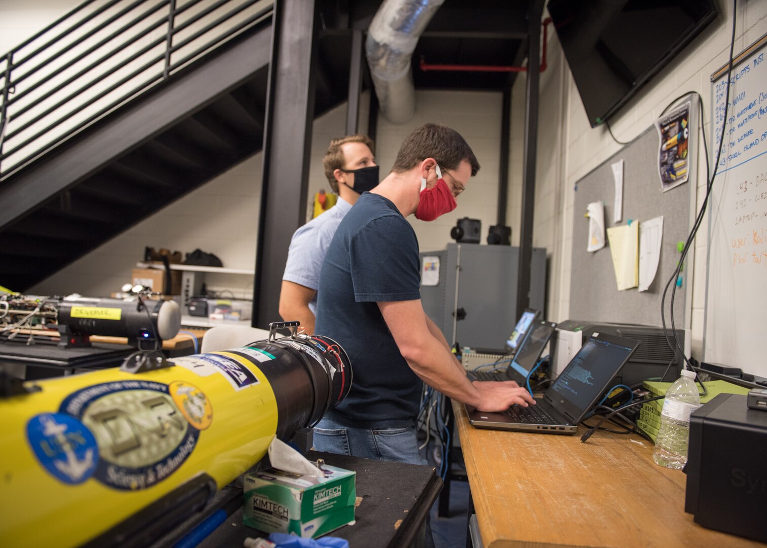Adam Coffman, NSWC PCD computer engineer, left, and Jason Bennett, computer scientist, right, attempts to gain access to the unmanned system’s internal software. U.S. Navy photo by Anthony Powers