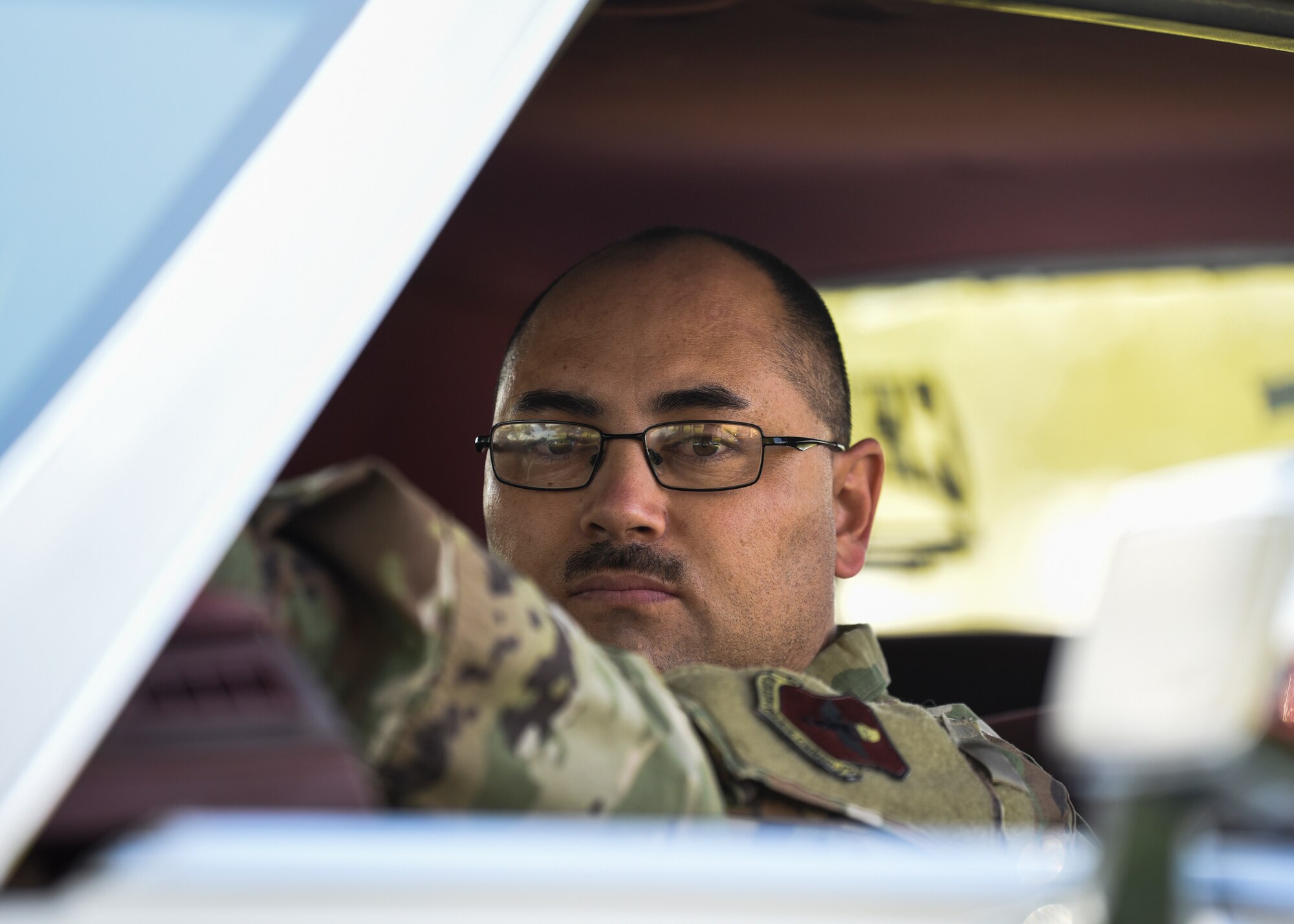 Airman poses in a car for car show.