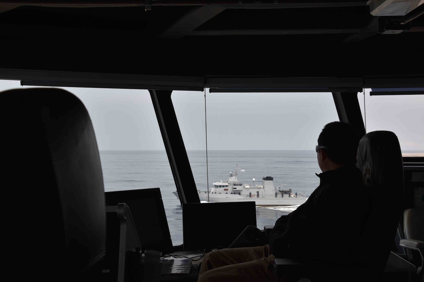 SOUTH CHINA SEA (Oct. 6, 2020) USNS Millinocket (T-EPF 3) Master Capt. Erwin Lao watches as the Royal Brunei Navy offshore patrol vessel KDB Daruttaqwa (DTQ 09) and inshore patrol vessel KDB Syafaat (SYA 19) conduct a ceremonial departure at the conclusion of the sea phase of Cooperation Afloat Readiness and Training (CARAT) Brunei. This year marks the 26th iteration of CARAT, a multinational exercise designed to enhance U.S. and partner navies' abilities to operate together in response to traditional and non-traditional maritime security challenges in the Indo-Pacific region. (U.S. Navy photo by Third Officer (3/O) Surafel Asfaw)