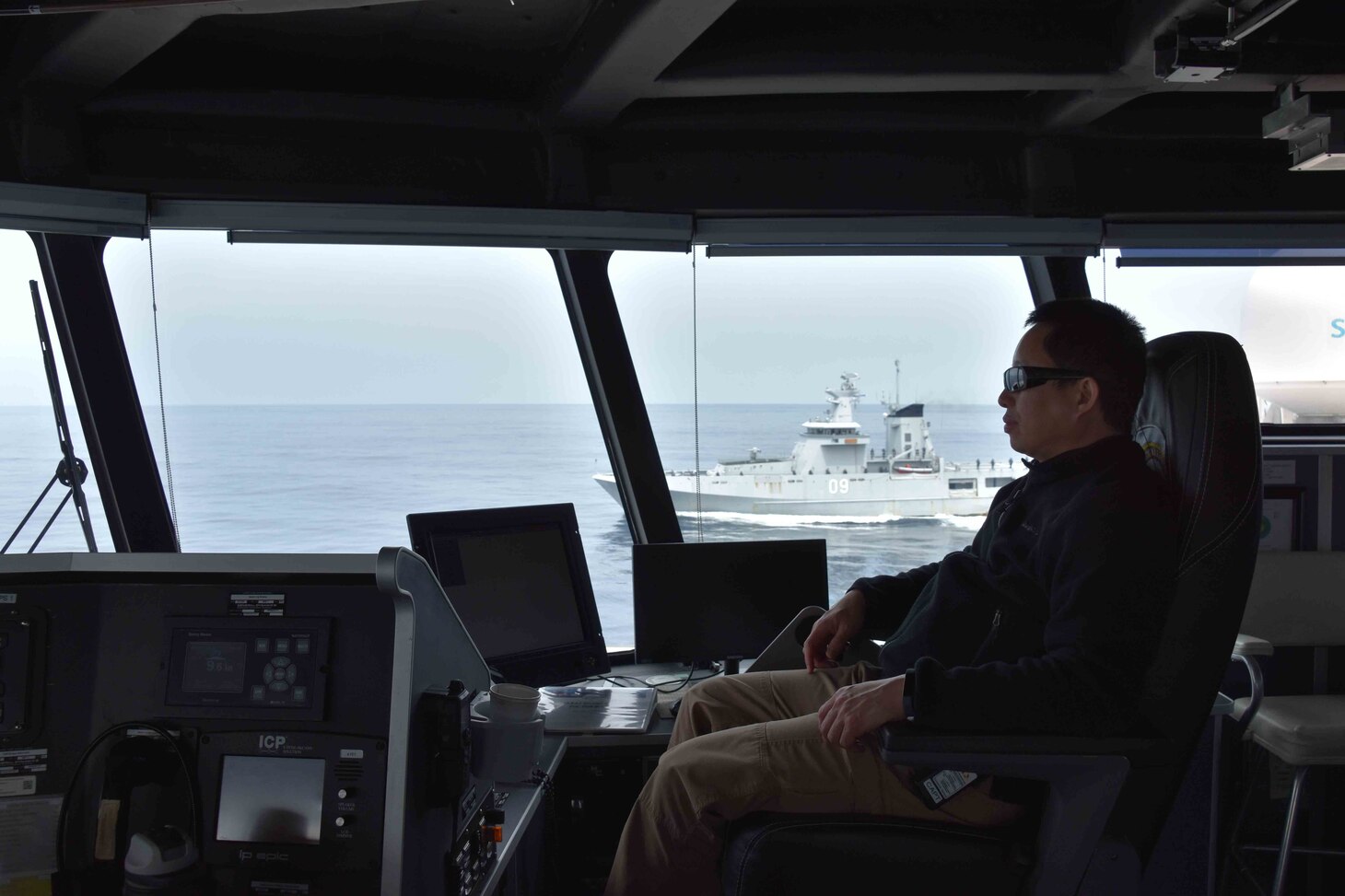SOUTH CHINA SEA (Oct. 6, 2020) USNS Millinocket (T-EPF 3) Master Capt. Erwin Lao watches as the Royal Brunei Navy offshore patrol vessel KDB Daruttaqwa (DTQ 09) and inshore patrol vessel KDB Syafaat (SYA 19) conduct a ceremonial departure at the conclusion of the sea phase of Cooperation Afloat Readiness and Training (CARAT) Brunei. This year marks the 26th iteration of CARAT, a multinational exercise designed to enhance U.S. and partner navies' abilities to operate together in response to traditional and non-traditional maritime security challenges in the Indo-Pacific region. (U.S. Navy photo by Third Officer (3/O) Surafel Asfaw)