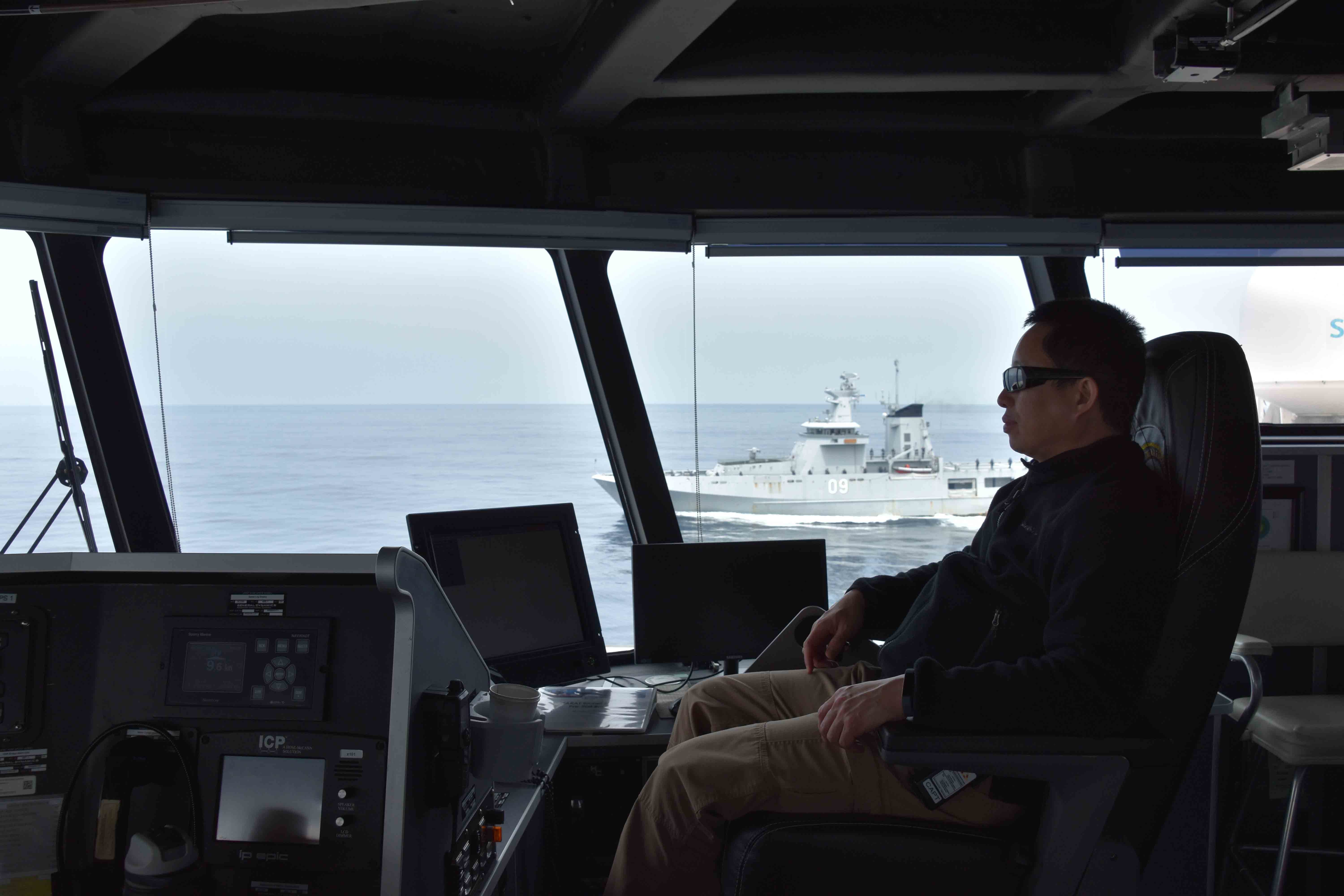 SOUTH CHINA SEA (Oct. 6, 2020) USNS Millinocket (T-EPF 3) Master Capt. Erwin Lao watches as the Royal Brunei Navy offshore patrol vessel KDB Daruttaqwa (DTQ 09) and inshore patrol vessel KDB Syafaat (SYA 19) conduct a ceremonial departure at the conclusion of the sea phase of Cooperation Afloat Readiness and Training (CARAT) Brunei. This year marks the 26th iteration of CARAT, a multinational exercise designed to enhance U.S. and partner navies' abilities to operate together in response to traditional and non-traditional maritime security challenges in the Indo-Pacific region. (U.S. Navy photo by Third Officer (3/O) Surafel Asfaw)