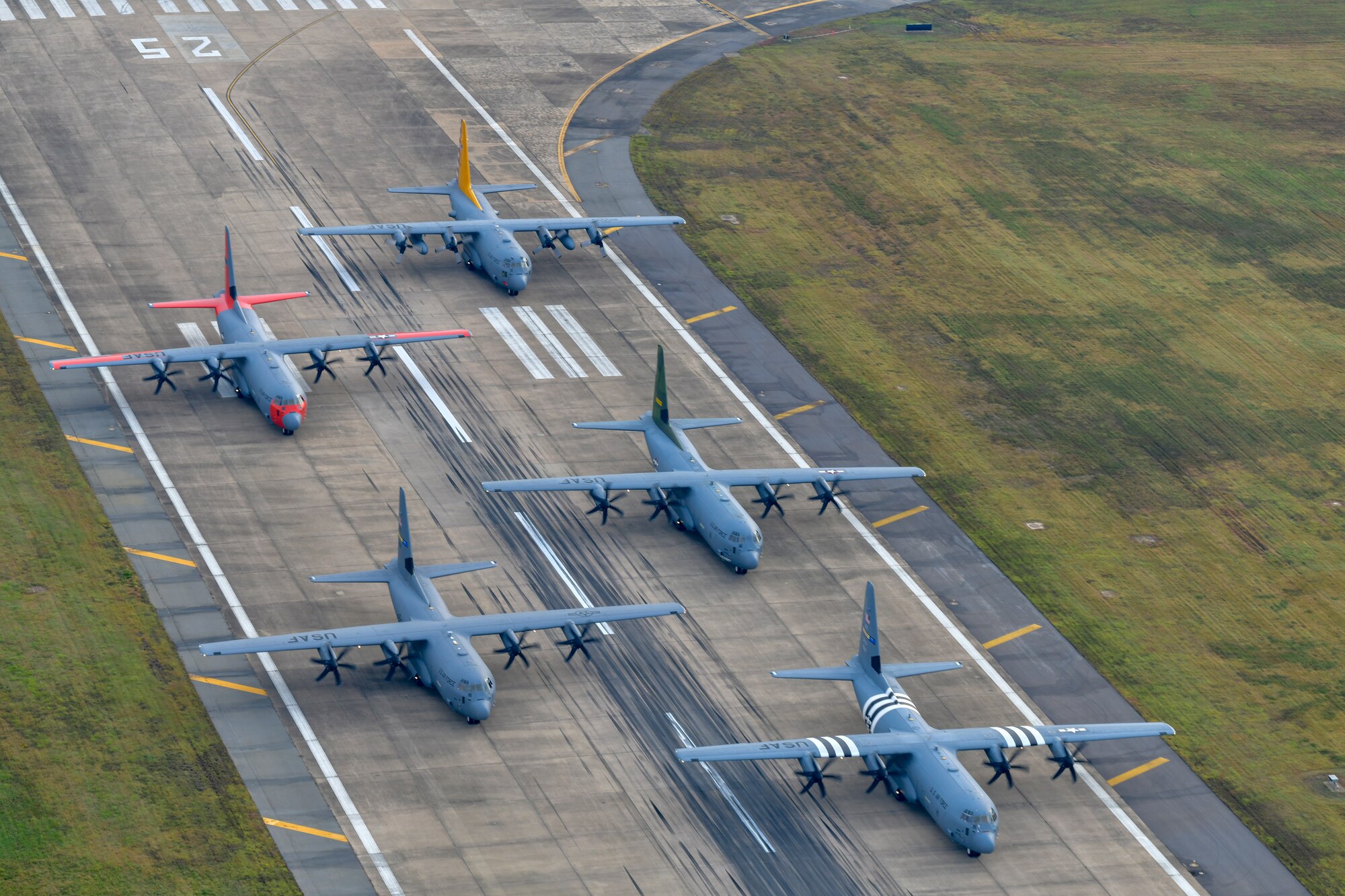 5 Planes sit on runway with engines running