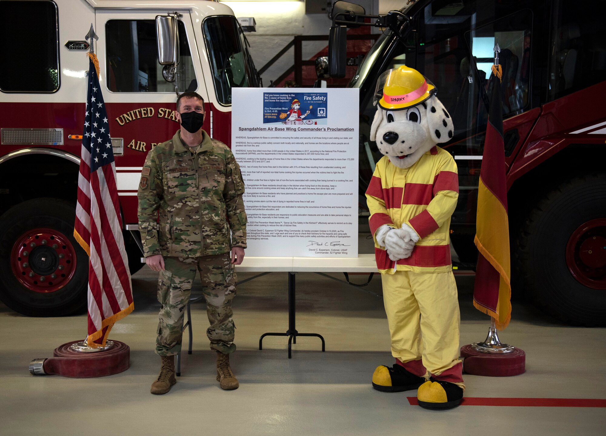 U.S. Air Force Col. David Epperson, 52nd Fighter Wing commander, and Sparky, the fire dog, pose for a photo after the signing of the Spangdahlem Air Base Wing Commander’s Proclamation, Oct. 5, 2020, at Spangdahlem AB, Germany. The Wing Commander’s Proclamation ensures Saber families will take necessary measures to prevent home fires and continue to educate themselves on fire prevention safety measures. (U.S. Air Force photo by Senior Airman Melody W. Howley)
