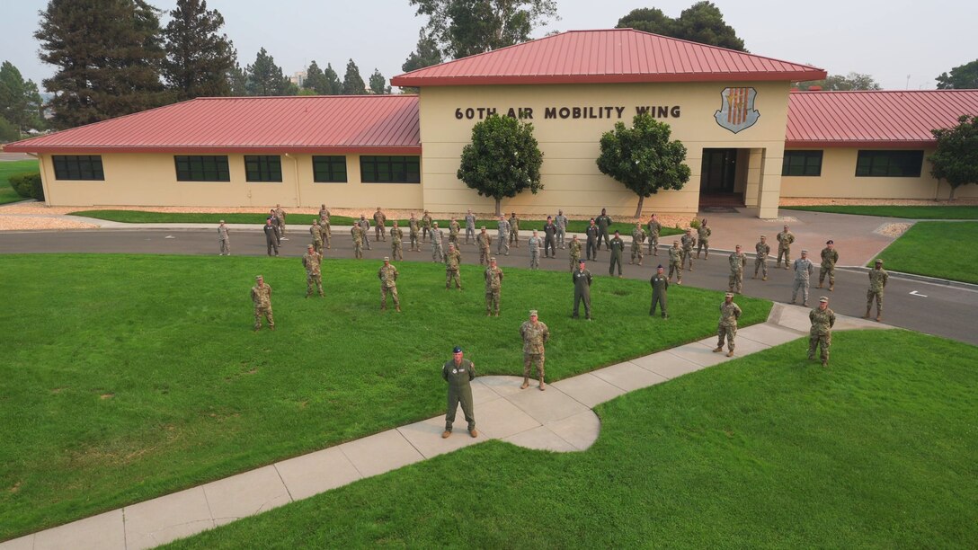 A group of Airmen standing in front of the wing headquarters building on Travis AFB.