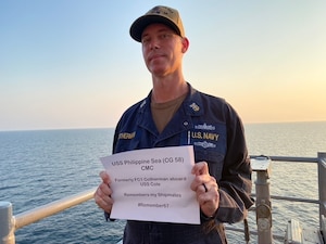 Acting Command Master Chief Aegis Fire Controlman Craig Cotherman, assigned to the guided-missile cruiser USS Philippine Sea (CG 58), honors his shipmates killed when the USS Cole was attacked on Oct. 12, 2000.