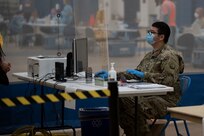 Specialist Nathan Nelson, a member of the West Virginia National Guard’s Task Force Chemical, Biological, Radiological and Nuclear (CBRN) Response Enterprise (CRE) (TF-CRE), registers an individual for a COVID-19 nasal swab test, West Virginia University Student Recreation Center, 30 Sept., 2020. TF-CRE members have assisted on COVID-19 testing lines with state health departments since March. (U.S. Air National Guard photo by Staff Sgt. Timothy Sencindiver)