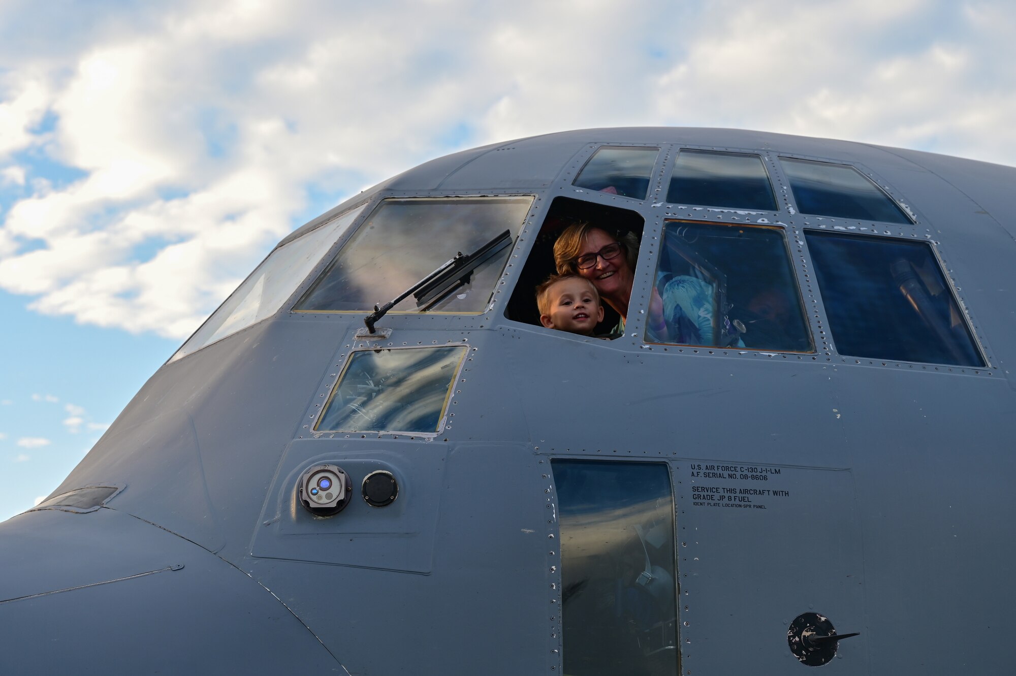 And elderly woman and child look out the window of a C-130
