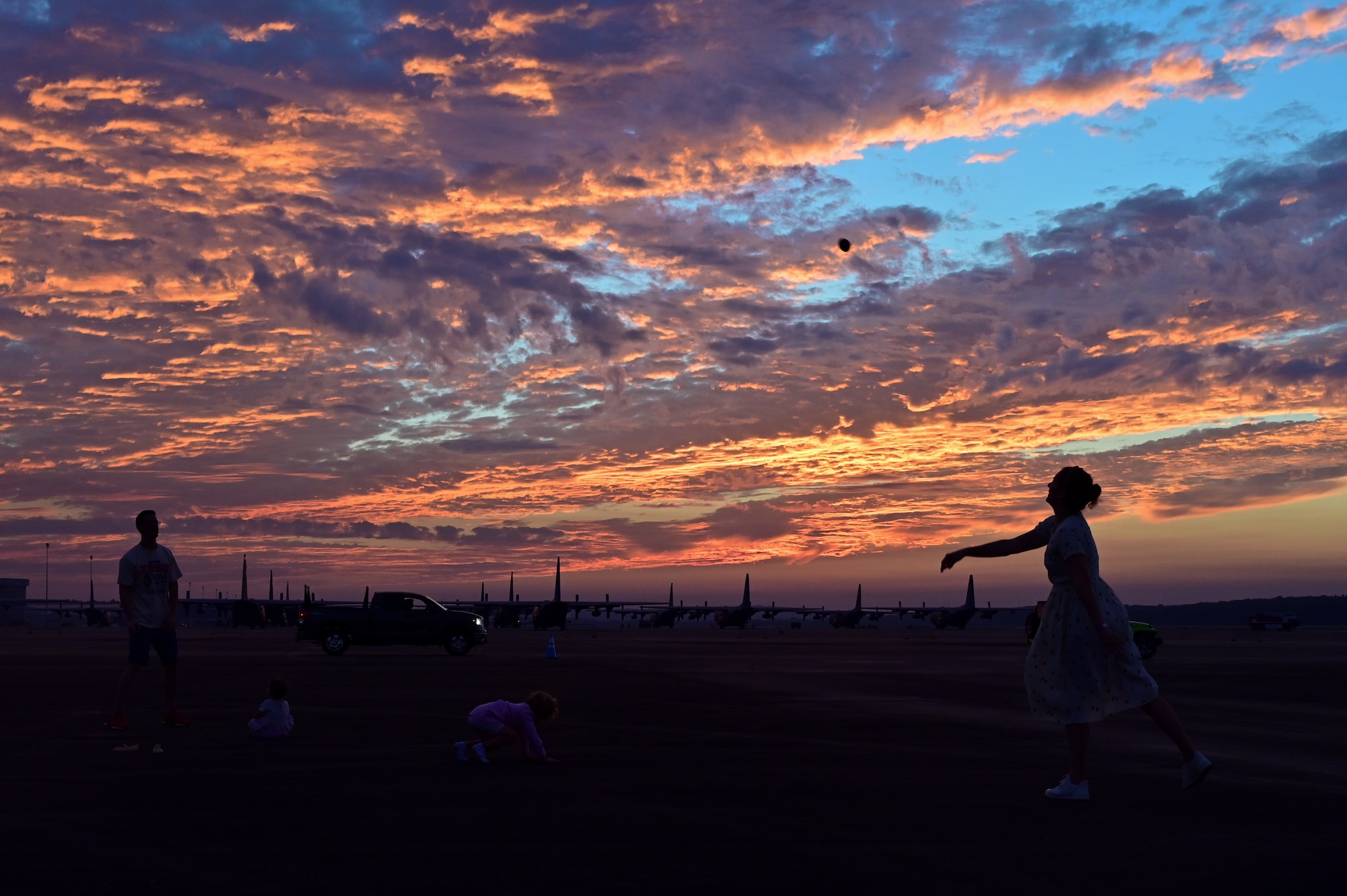 A family throws a football to wach other on the flightline