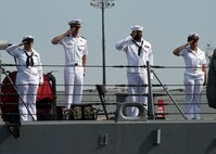 Sailors render honors as the guided-missile destroyer USS Cole (DDG 67) departs Naval Station Norfolk on a deployment to the U.S. 6th Fleet area of responsibility.