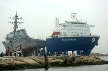 The USS Cole (DDG 67) aboard the Blue Marline was escorted into a U.S. port for the first time since the attack.