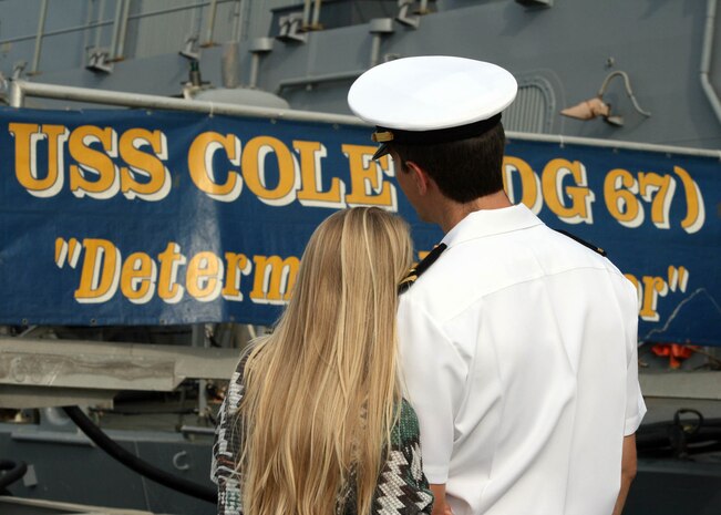 Ensign Dustin Backer, from Brentwood, Tenn., hugs his wife goodbye before departing Naval Station Norfolk aboard the guided-missile destroyer USS Cole (DDG 67).