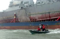The USS Cole (DDG 67) aboard the Blue Marlin was escorted into a U.S. port for the first time since the attack.