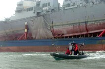 The USS Cole (DDG 67) aboard the Blue Marlin was escorted into a U.S. port for the first time since the attack.