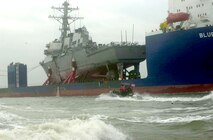 The USS Cole (DDG 67) aboard the Blue Marlin was escorted into a U.S. port for the first time since the attack.