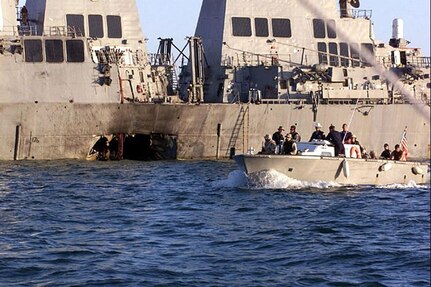Archive photo from Oct. 18, 2000, re-released. U.S. Navy and Marine Corps security personnel patrol pass the damaged U.S. Navy destroyer USS Cole (DDG 67) following the Oct. 12, 2000 terrorist bombing attack on the ship in Aden, Yemen.