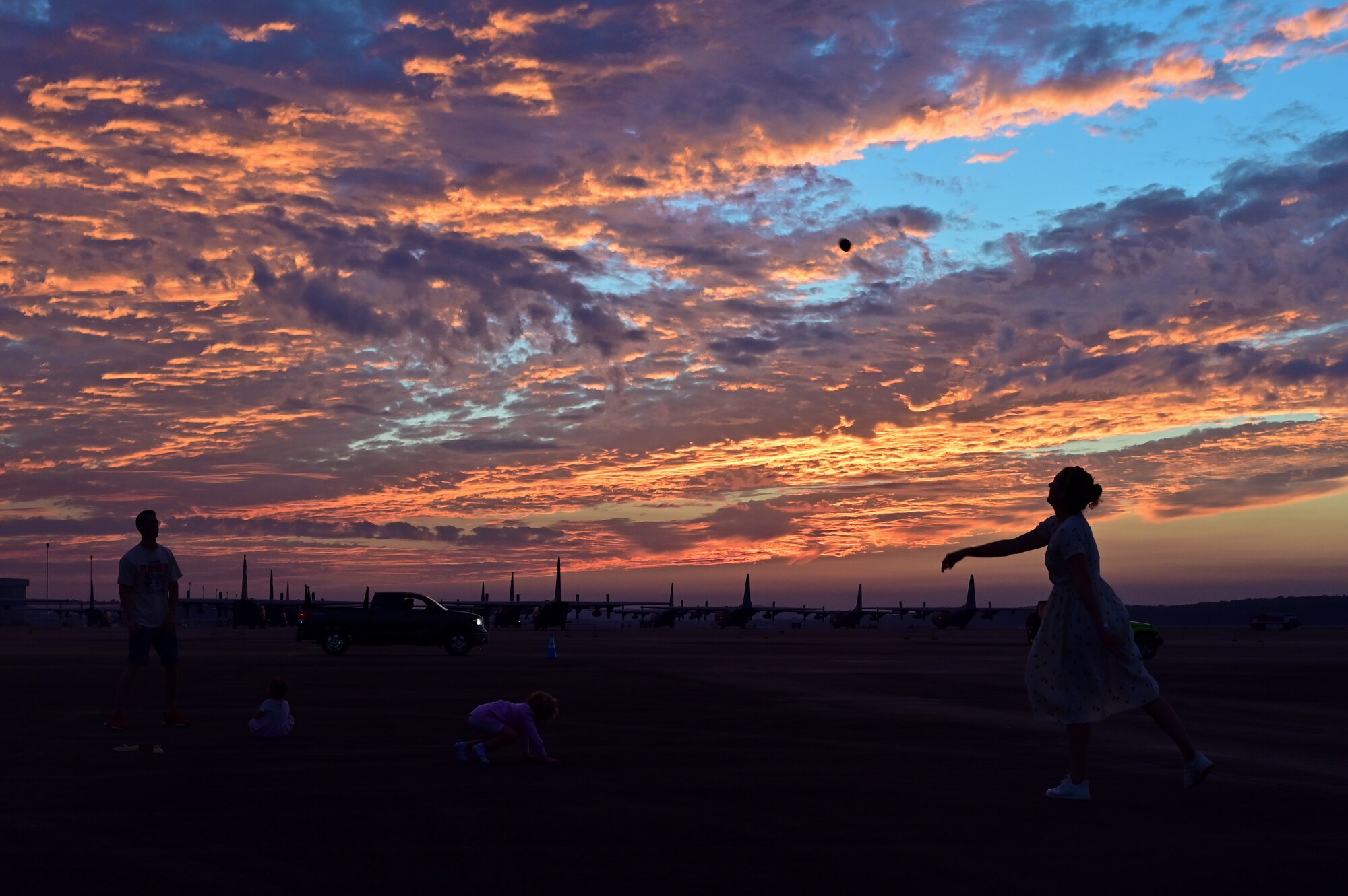 A family throws a football to wach other on the flightline