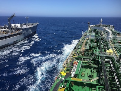 Two ships side by side perform a consolidated cargo replenishment-at-sea