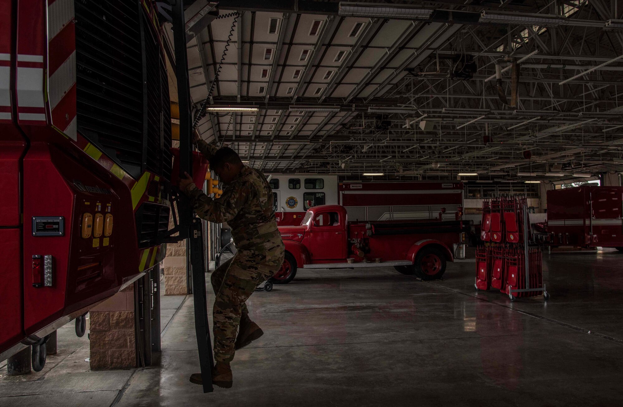 Airman 1st Class Marwane Hsaini, 4th Civil Engineer Squadron fireman, climbs down the ladder of a new fire truck after filling it with a bucket of water at Seymour Johnson Air Force Base, N.C., Oct. 9, 2020. During the ceremonial exchange of fire trucks, the water leftover in the old truck is exchanged into the new one. (U.S. Air Force photo by Senior Airman Kylee Gardner)